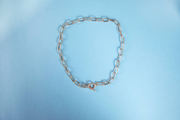 istock golden necklace on blue table background 1343567339
