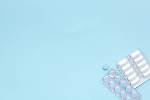 istock Blisters of white and blue pills on blue background, top view. Different pharmaceuticals, tablets, medicine capsules. Treatment concept. Painkiller. 1343569329