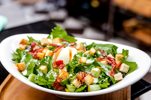 A white bowl of salad Caesar photography