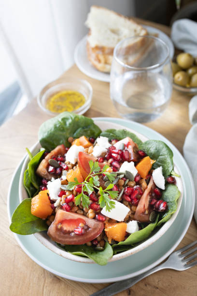 istock Lentil salad with pumpkin, tomatoes, pomegranate seeds, spinach and goat cheese. 1343569527
