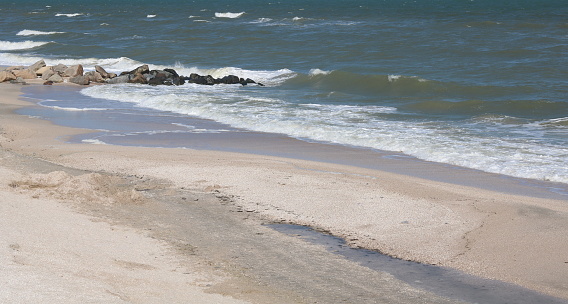 german bunker at beach of Hourdel in France at low tide on sunny summer day, wooden groyne in the foreground