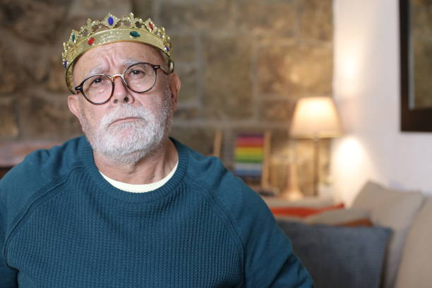 Spoiled senior man with brat expression wearing a crown.