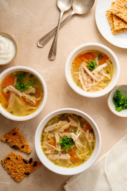 istock Chicken noodle soup, three bowls with vegetable broth, top view. 1343574869