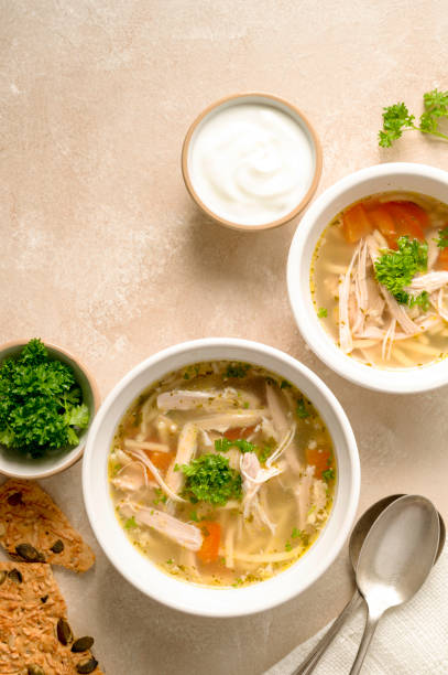 Chicken noodle soup, two bowls with vegetable broth, top view. Chicken noodle soup, two bowls with vegetable broth top view chicken soup stock pictures, royalty-free photos & images