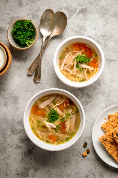 istock Chicken noodle soup, two bowls with vegetable broth, top view. 1343575251