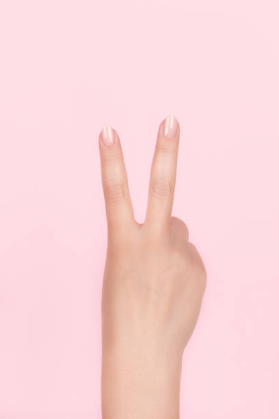 A human hand  make the victory V-sign, victory peace gesture,  and means two in the chinese hand language, isolated on black .