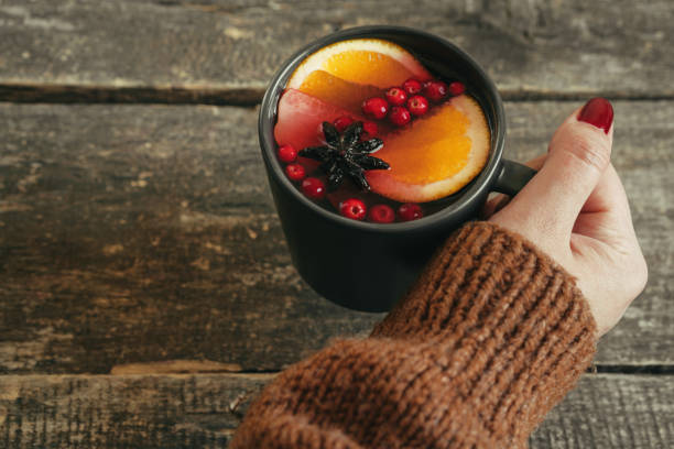 istock Woman's hands in warm sweater holding a cup of mulled wine 1343576581