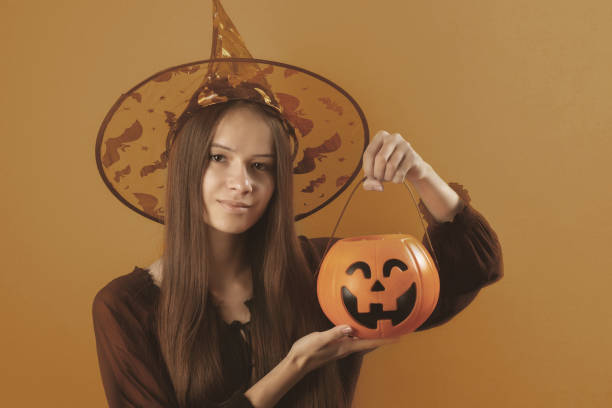 istock Halloween,teenager dressed as a witch with a pumpkin 1343576906