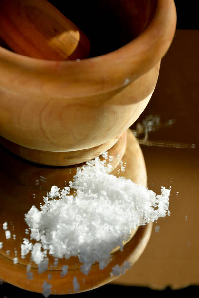 istock Flake salt in semi-shadow with reflections next to a wooden mortar 1343577557