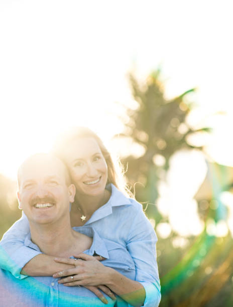 pareja de luna de miel en retrato feliz con destellos de sol y sonrisas - honeymoon beach couple heterosexual couple fotografías e imágenes de stock