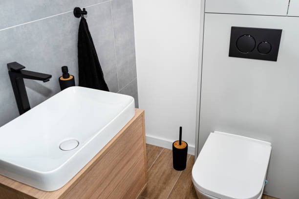 istock A white ceramic toilet with an closed flap in a modern restroom, a floor covered with ceramic tiles imitating wood. 1343583865