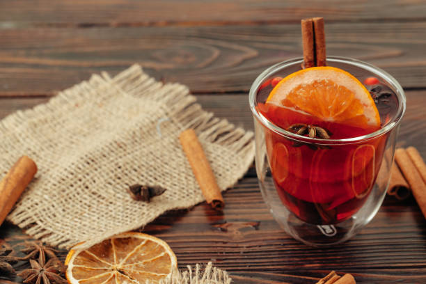 istock Close up of mulled wine cup with spices and berries on grey table 1343585741