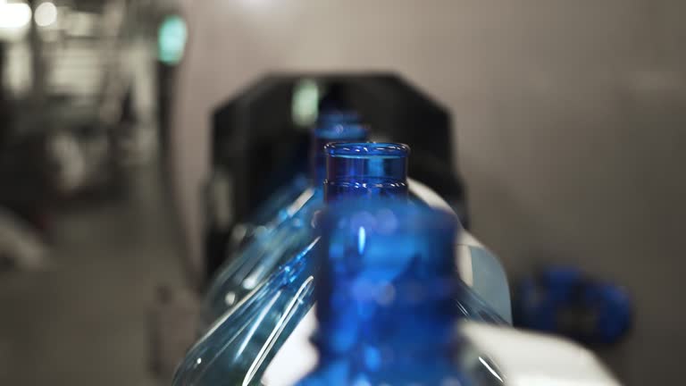 Plastic containers, bottles, go sequentially row along production conveyor line