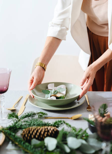 Christmas Celebration: An Anonymous Woman Setting Up Christmas Dinner Table