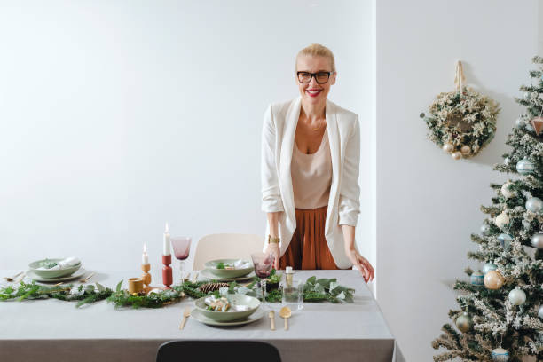 istock Christmas Preparation: Cheerful Woman Setting Up Christmas Dinner Table 1343587166