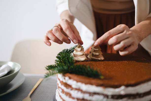 preparativos de nochevieja: una mujer anónima preparando la mesa de la cena de navidad - tarta de navidad fotografías e imágenes de stock
