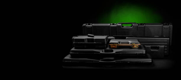 A variety of plastic cases for weapons. Strong containers for storing and transporting weapons against a dark background with a green spot of light.