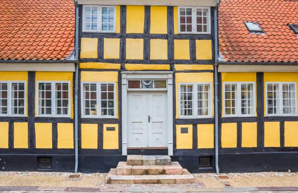 Front facade of a yellow half timbered house in Viborg, Denmark
