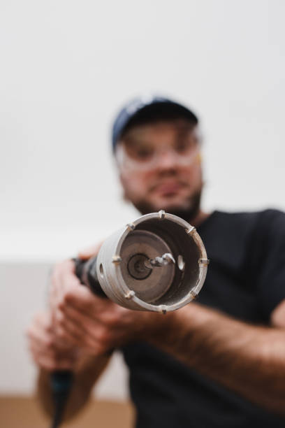 istock Construction worker electrician or plumber wearing a protective mask with a hammer drill 1343591962