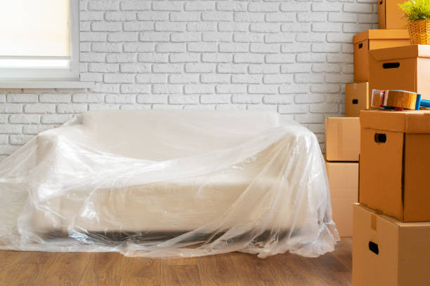 istock Packed sofa and stack of cardboard boxes in a room. Moving concept 1343593925