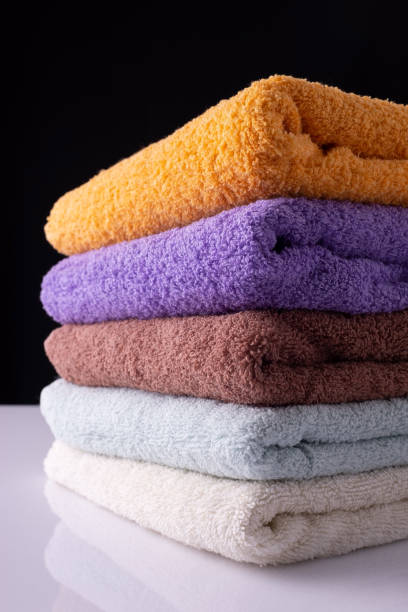 istock multicolored towels folded, on white table and black background 1343596030