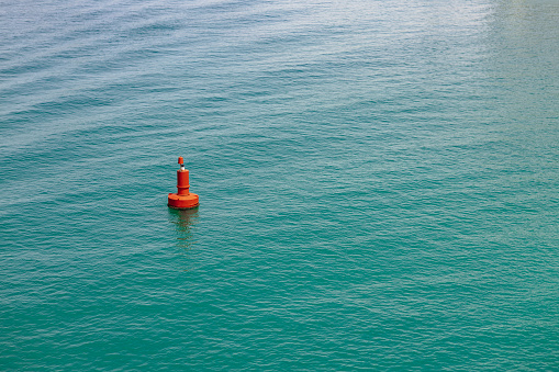 Single red buoy in the clear blue sea