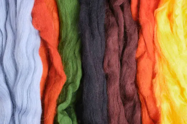 wool of different colors and textures. Background made of wool felting in the form of lines. top view