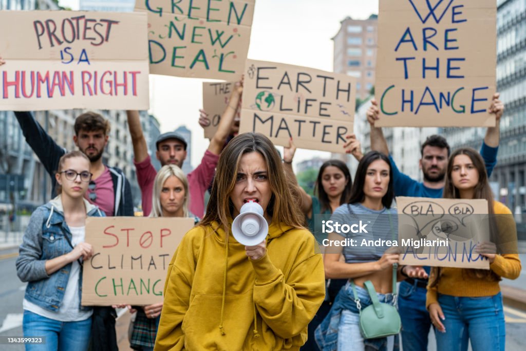 Group of multiethnic people making protest about climate change, public demonstration on the street against global warming and pollution. Protest Stock Photo