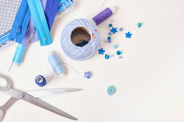istock lace, spools of thread, scissors, fabrics, a zipper and accessories for sewing and needlework on the table, beads, buttons and pins 1343600818