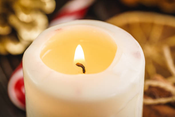 istock Burning Christmas candle close up on wooden table 1343603602