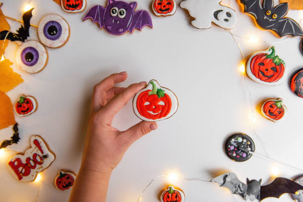 istock DIY Halloween gingerbread cookie. Step 4, fill the path with orange and green icing. 1343608421