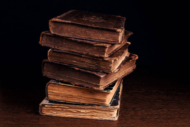 istock Stack of old worn shabby books in leather binding on dark background. Closeup. Selective focus. 1343609705