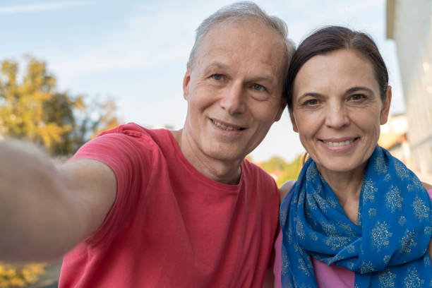 istock Mature couple taking selfie against blue sky 1343611448