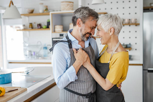 Romantic mature couple, dancing in the kitchen Cute mature couple dancing in the kitchen middle aged couple dancing stock pictures, royalty-free photos & images