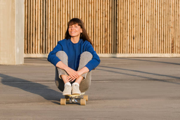 istock Young woman sitting on a skateboard in park. 1343612585