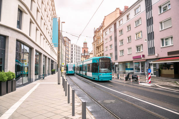 Trams running along a street lined with modern buildings in a city centre. Frankfurt, Germany.