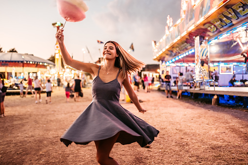 Funny moment of a beautiful woman dancing with Colorful Candy at an Amusement Park.