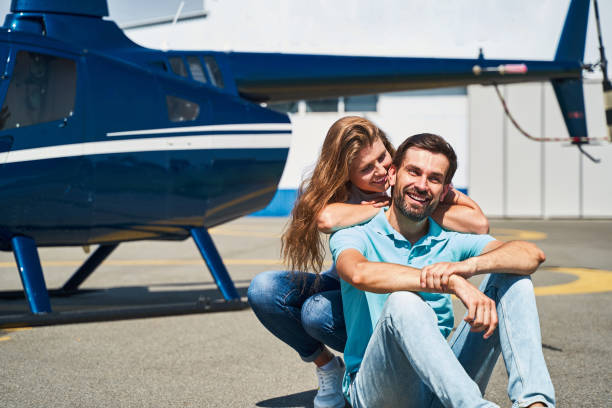 istock Romantic couple sitting on landing pad by helicopter 1343617264