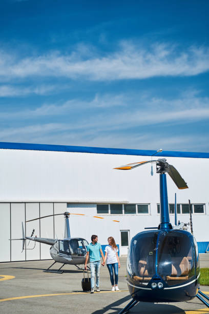 istock Cheerful woman and man with baggage approaching chopper 1343617339