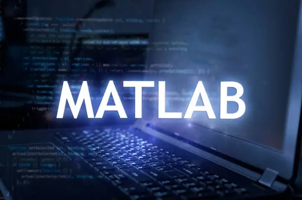 Photo of MATLAB inscription against laptop and code background.