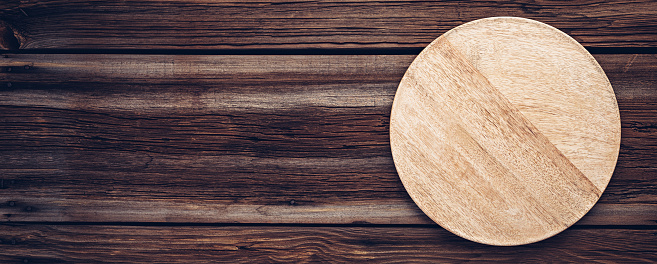 Wood pizza board or plate for food on old wooden planks.