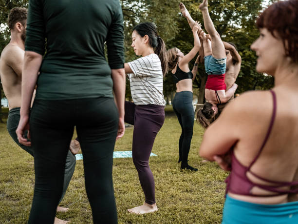 istock People practising Acro Yoga in the park 1343619523