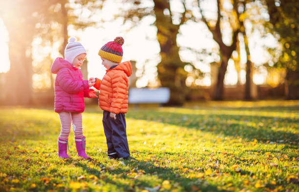 istock Two children playing in the park together 1343620633