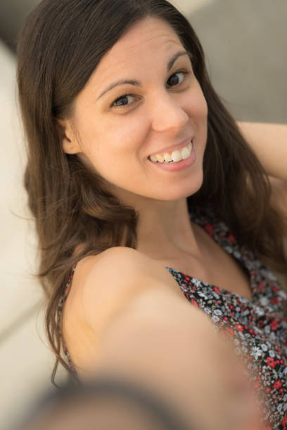 pretty girl smiles while taking a selfie
