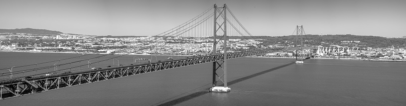view of the 25 de Abril bridge in the south-north direction, Almada Lisboa from the atrium of the Cristo Rei.  Black and white image.