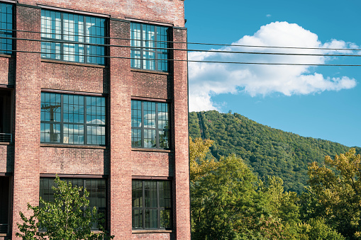 Industrial factory apartment building juxstaposed with natural mountain and sky