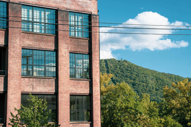 Industrial factory apartment building juxstaposed with natural mountain and sky stock photo