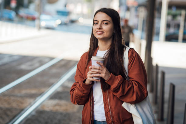 istock Girl standing on street with coffee 1343631955