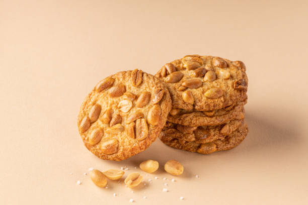 istock Cookies with roasted peanuts on top on beige background. 1343635749