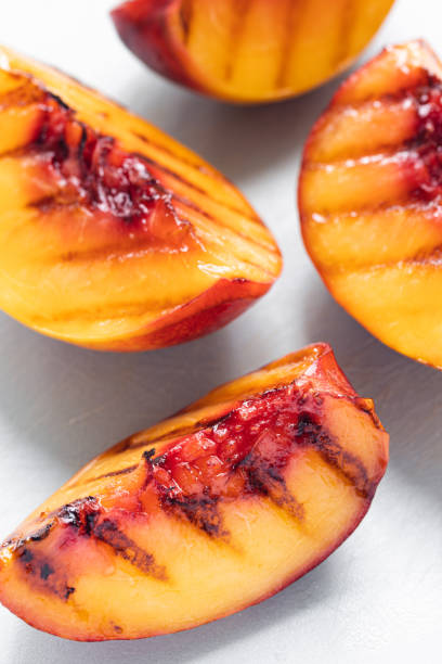 istock Juicy grilled nectarine quarters on light gray cutting board. 1343635750